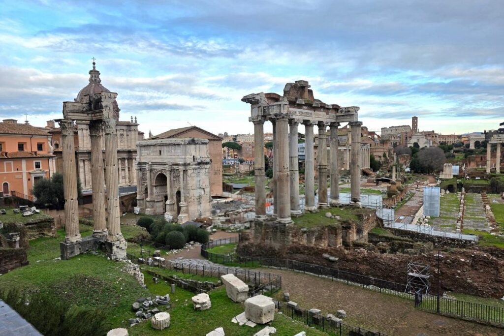 Ruinas del foro romano con el coliseo de fondo